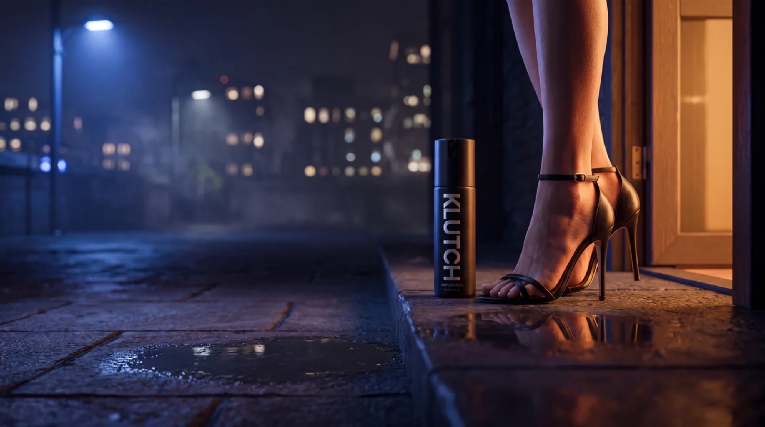 A woman in heels stepping onto a wet city sidewalk at night beside the Klutch Grip Control bottle
